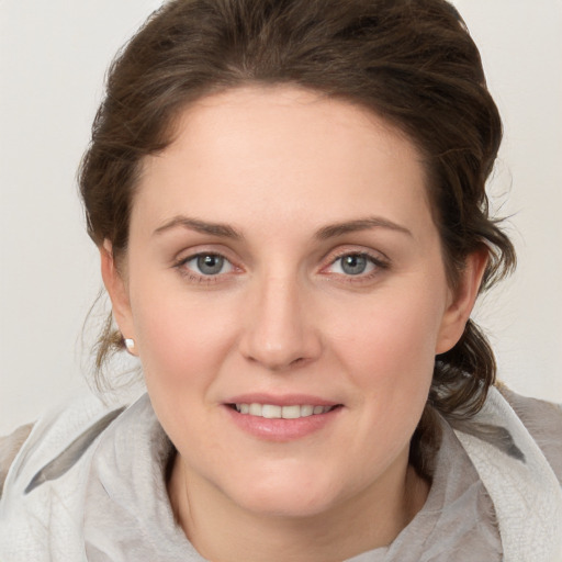 Joyful white young-adult female with medium  brown hair and grey eyes