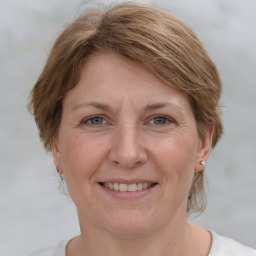 Joyful white adult female with medium  brown hair and grey eyes