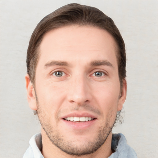 Joyful white young-adult male with short  brown hair and grey eyes