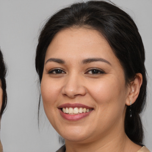 Joyful latino young-adult female with medium  brown hair and brown eyes