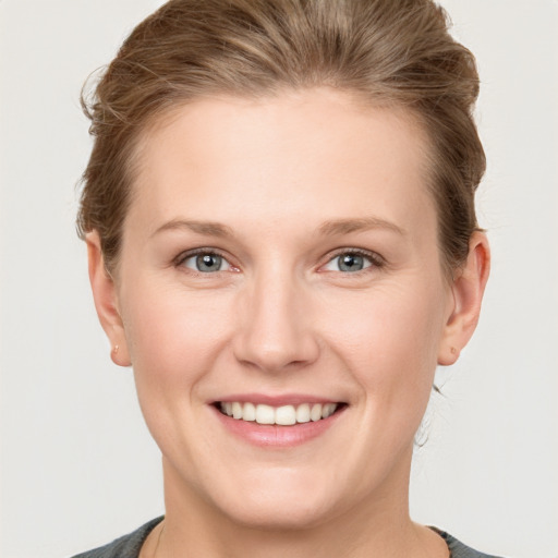 Joyful white young-adult female with short  brown hair and grey eyes