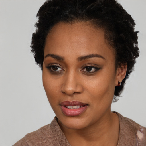 Joyful black young-adult female with short  black hair and brown eyes