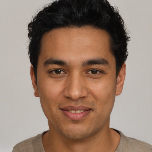 Joyful latino young-adult male with short  black hair and brown eyes