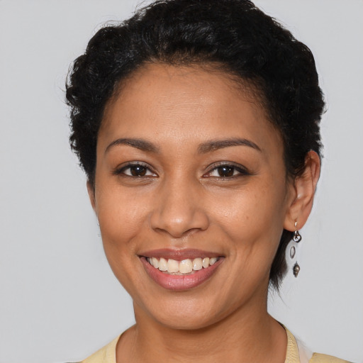 Joyful latino young-adult female with short  black hair and brown eyes
