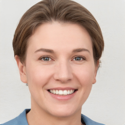 Joyful white young-adult female with short  brown hair and grey eyes