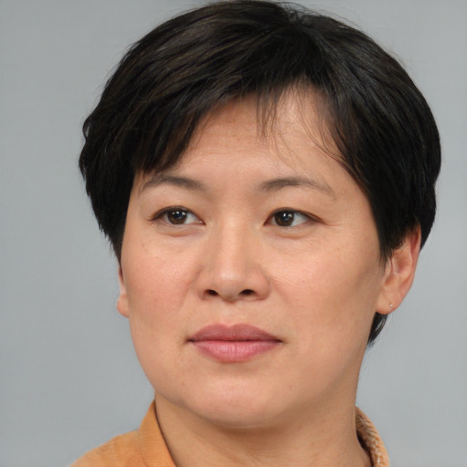 Joyful asian adult female with short  brown hair and brown eyes