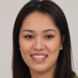 Joyful latino young-adult female with long  brown hair and brown eyes