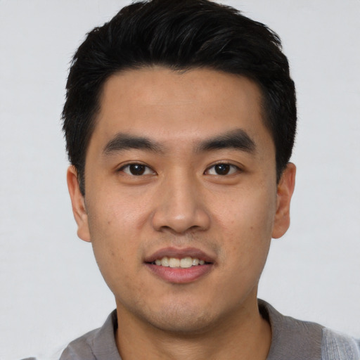 Joyful asian young-adult male with short  black hair and brown eyes