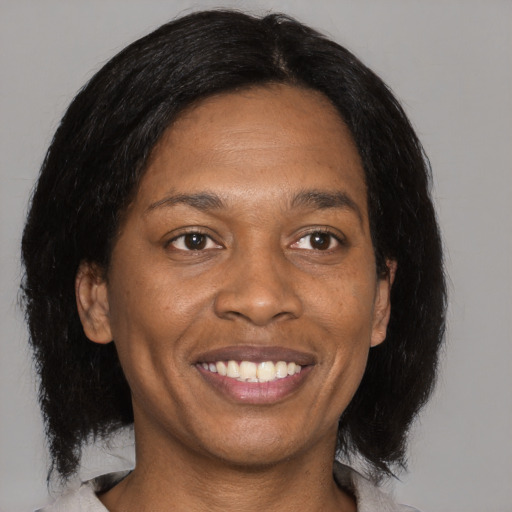 Joyful black adult female with medium  black hair and brown eyes