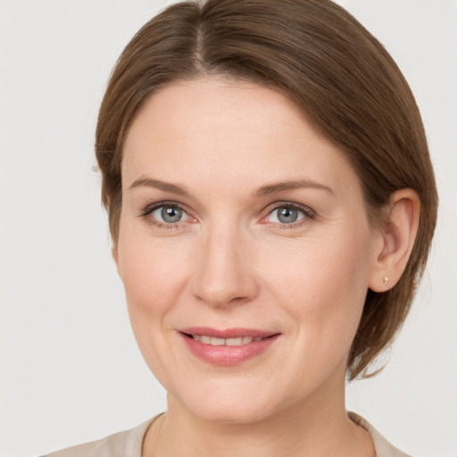 Joyful white young-adult female with medium  brown hair and grey eyes