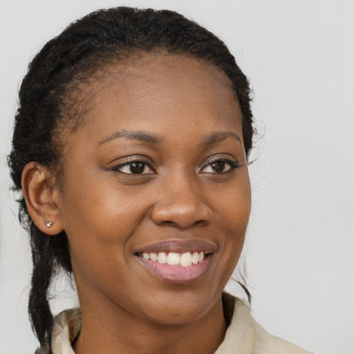 Joyful black young-adult female with long  brown hair and brown eyes