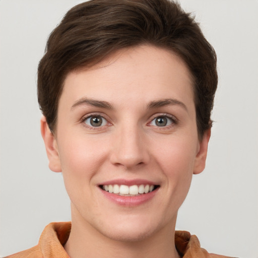 Joyful white young-adult female with short  brown hair and grey eyes