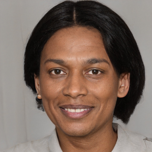 Joyful black adult female with medium  black hair and brown eyes