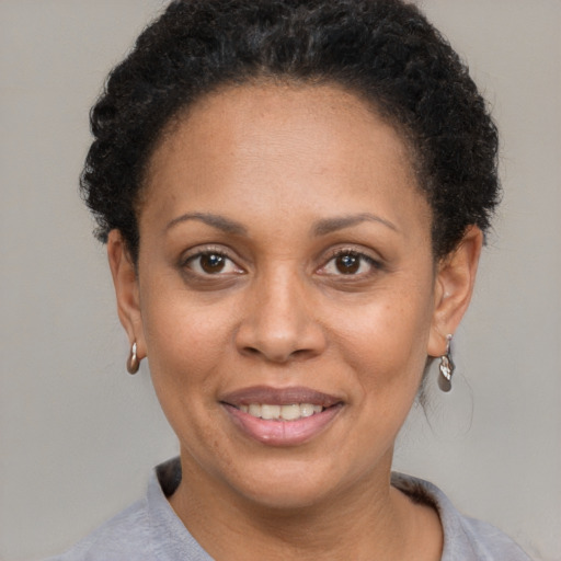 Joyful black adult female with short  brown hair and brown eyes