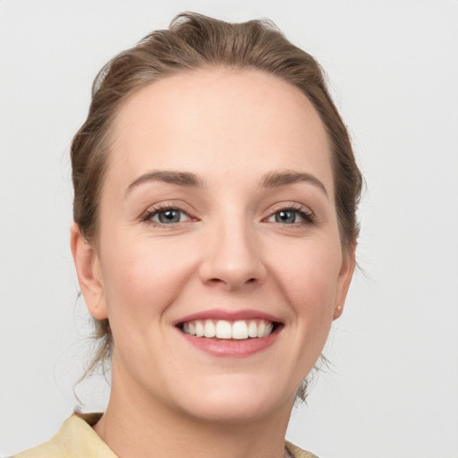 Joyful white young-adult female with medium  brown hair and grey eyes