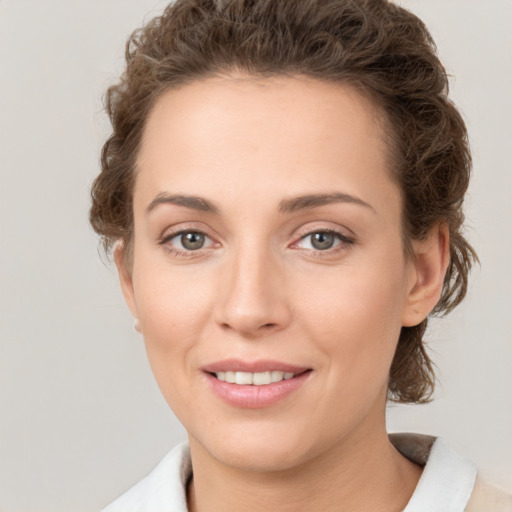 Joyful white young-adult female with medium  brown hair and green eyes