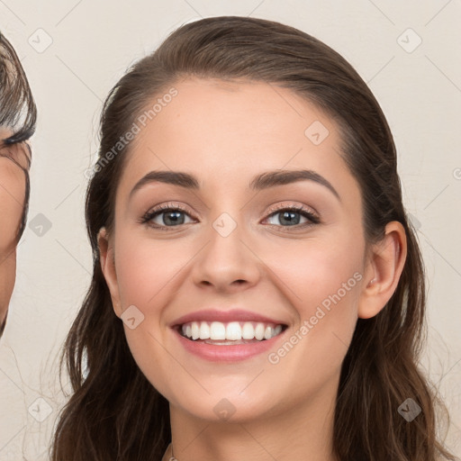 Joyful white young-adult female with long  brown hair and grey eyes