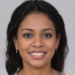 Joyful latino young-adult female with long  brown hair and brown eyes