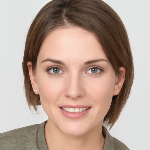 Joyful white young-adult female with medium  brown hair and grey eyes