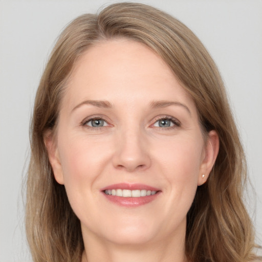 Joyful white adult female with long  brown hair and grey eyes