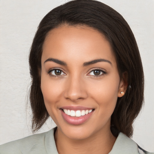 Joyful latino young-adult female with medium  brown hair and brown eyes