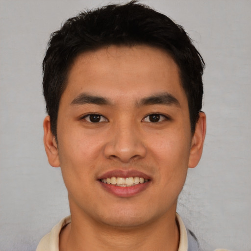 Joyful asian young-adult male with short  brown hair and brown eyes