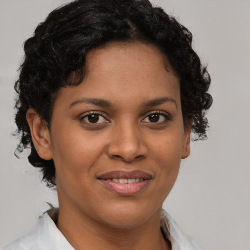 Joyful black young-adult female with short  brown hair and brown eyes