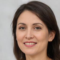 Joyful white adult female with long  brown hair and brown eyes