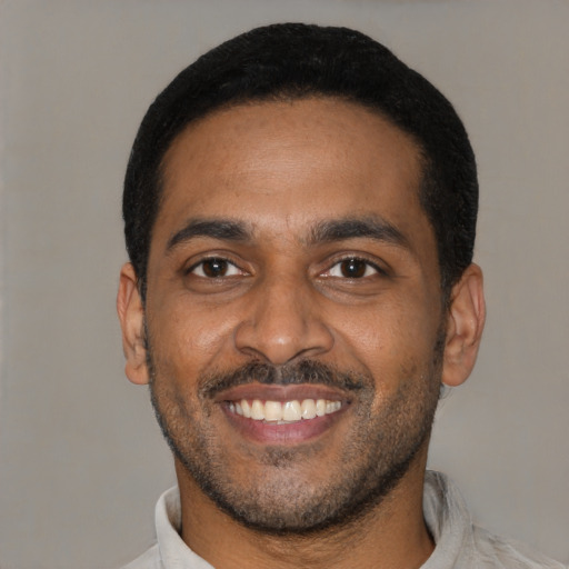 Joyful latino young-adult male with short  black hair and brown eyes