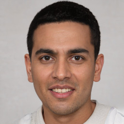 Joyful white young-adult male with short  black hair and brown eyes