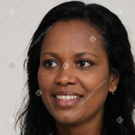 Joyful black young-adult female with long  black hair and brown eyes
