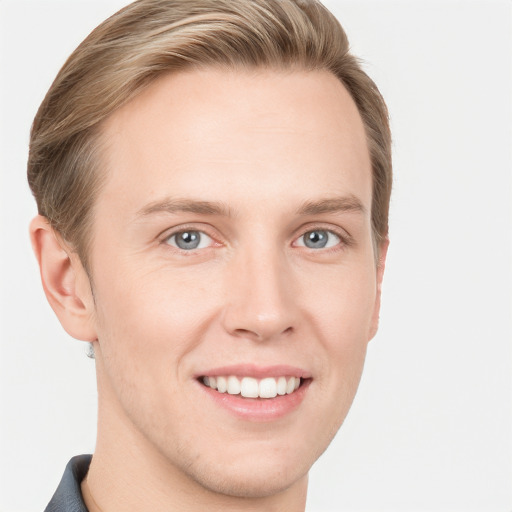 Joyful white young-adult male with short  brown hair and grey eyes