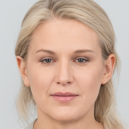 Joyful white young-adult female with medium  blond hair and grey eyes