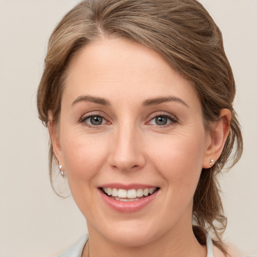 Joyful white young-adult female with medium  brown hair and blue eyes