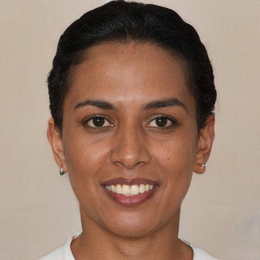 Joyful black young-adult female with short  black hair and brown eyes