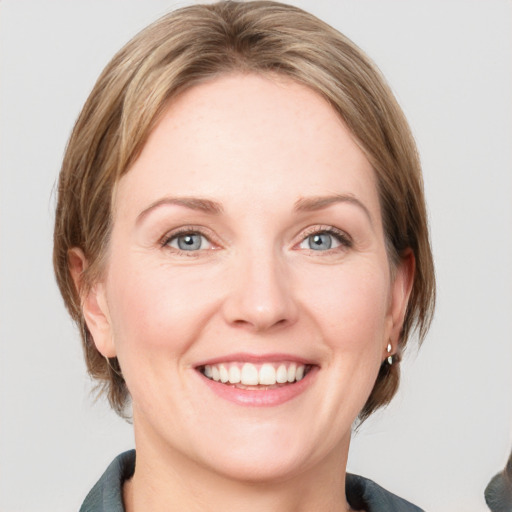 Joyful white adult female with medium  brown hair and blue eyes