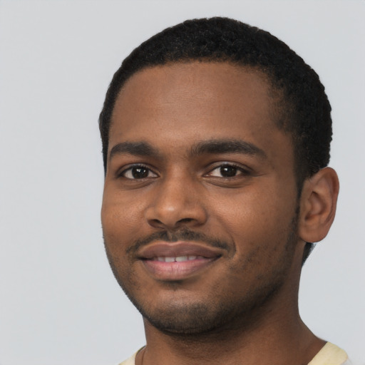 Joyful black young-adult male with short  black hair and brown eyes