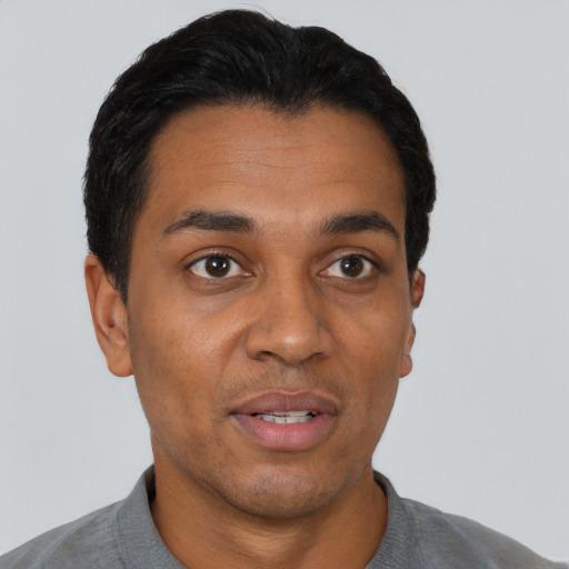 Joyful latino adult male with short  black hair and brown eyes