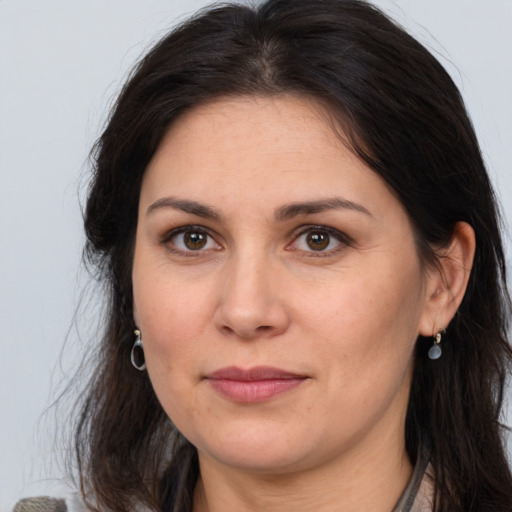 Joyful white adult female with long  brown hair and brown eyes