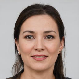 Joyful white young-adult female with medium  brown hair and grey eyes