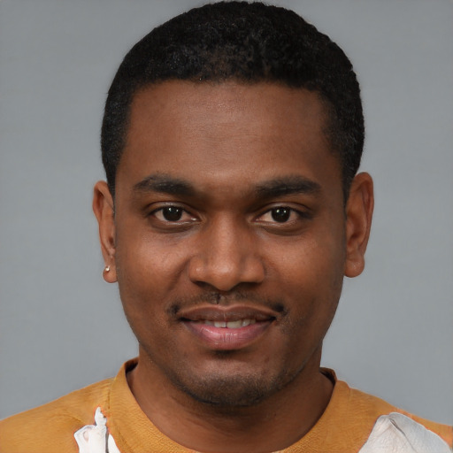 Joyful black young-adult male with short  black hair and brown eyes