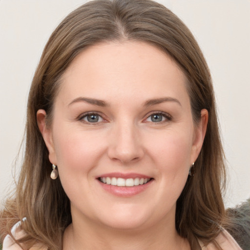 Joyful white young-adult female with medium  brown hair and grey eyes