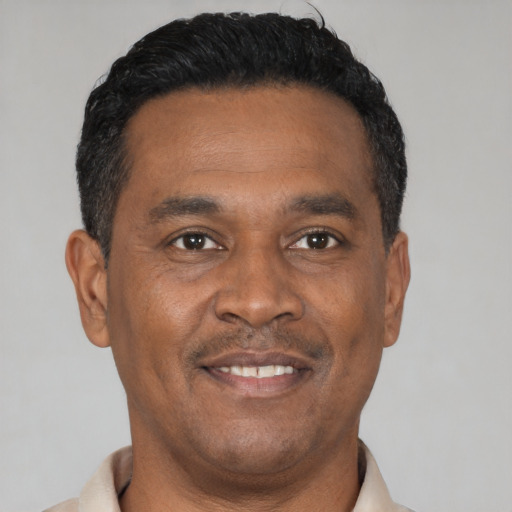 Joyful black adult male with short  black hair and brown eyes