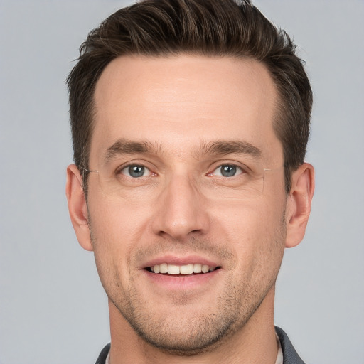 Joyful white young-adult male with short  brown hair and grey eyes