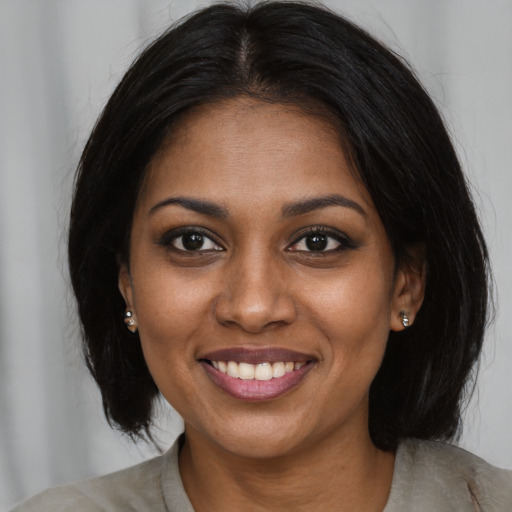 Joyful black young-adult female with medium  black hair and brown eyes