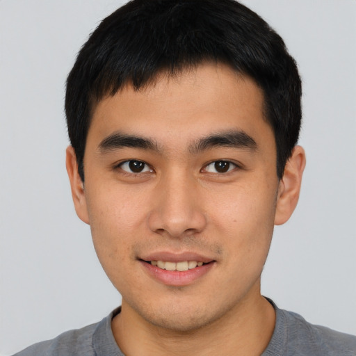 Joyful asian young-adult male with short  brown hair and brown eyes