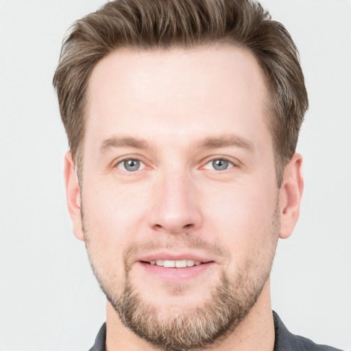 Joyful white young-adult male with short  brown hair and grey eyes