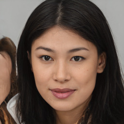 Joyful asian young-adult female with long  brown hair and brown eyes