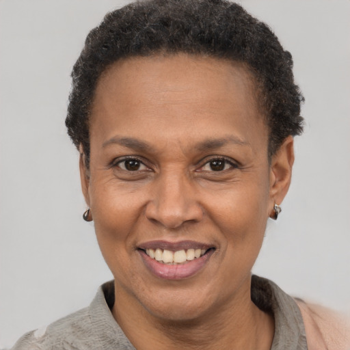 Joyful black adult female with short  brown hair and brown eyes