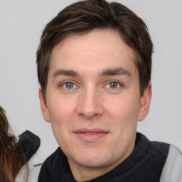 Joyful white adult male with short  brown hair and grey eyes